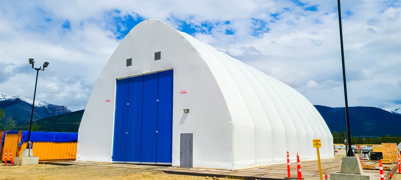 White Calhoun fabric building on galvanised steel legs with a roller door