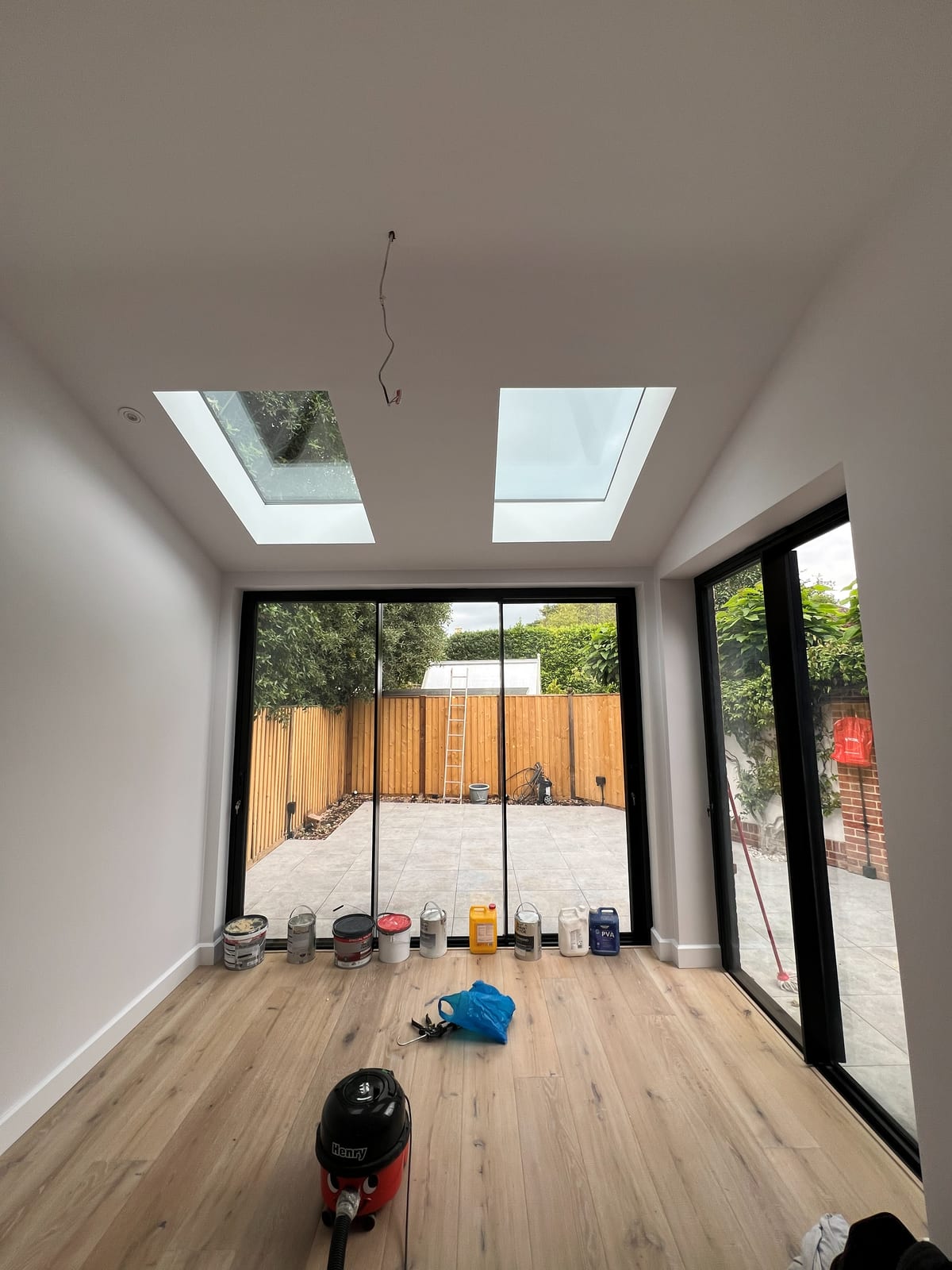 New open-plan room inside the extension with two roof lights and full-width sliding doors opening to the garden